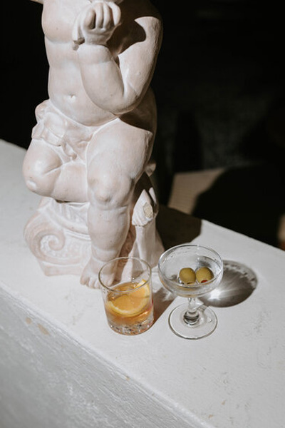 Wedding cocktail photographed beside an elegant classical sculpture