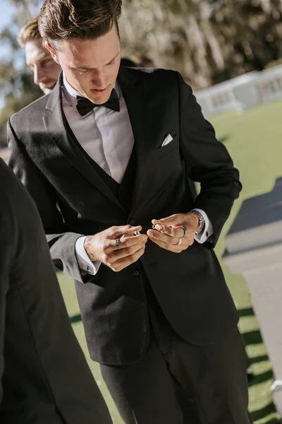 Groom adjusting his cufflinks while getting ready for the wedding