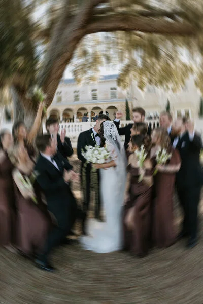 Creative motion blur photograph of a bride walking through wedding guests