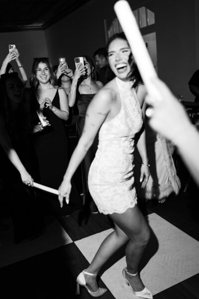 Bride dancing during the wedding reception with guests cheering