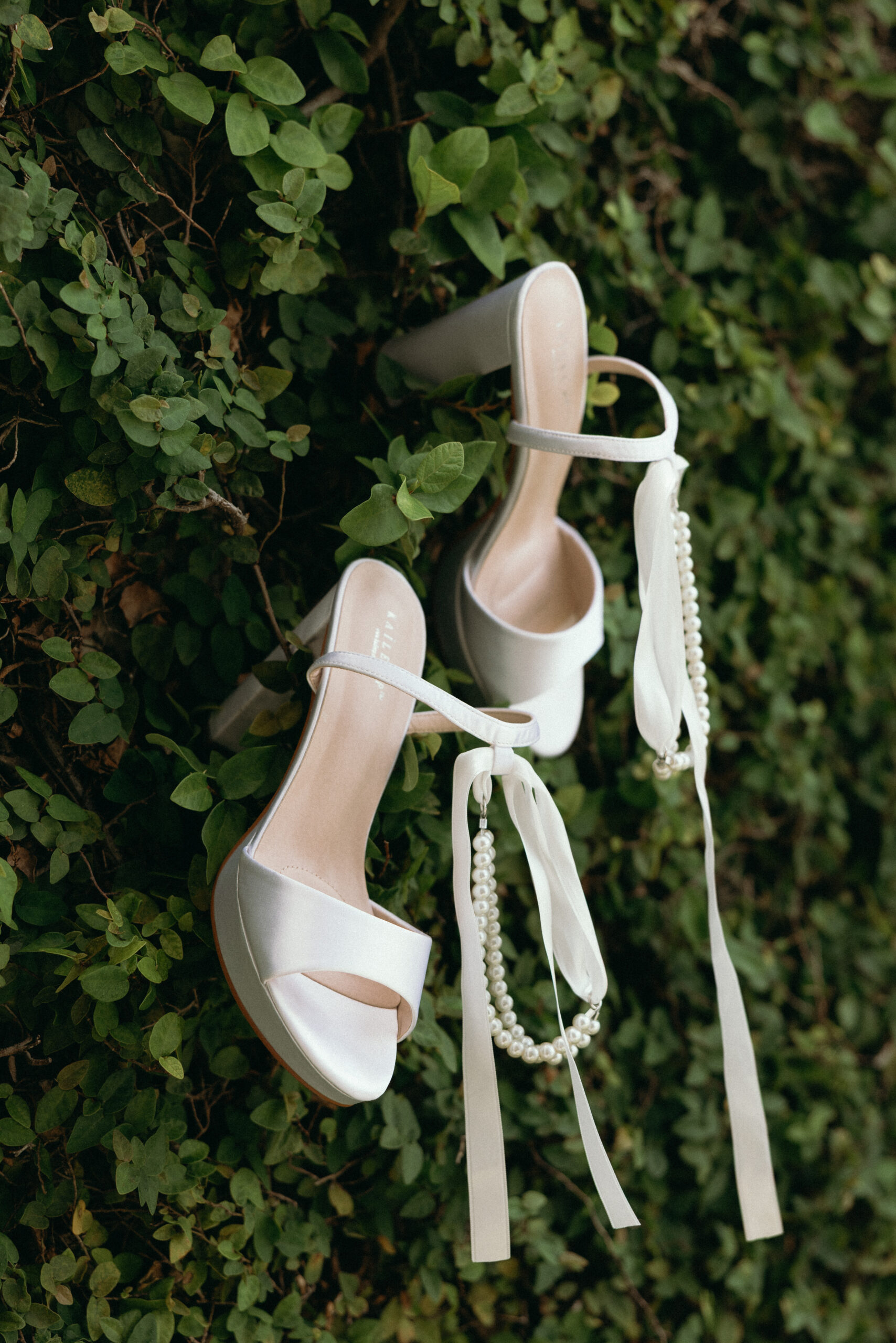Wedding shoes styled on greenery wall at The Club at The Strand Naples